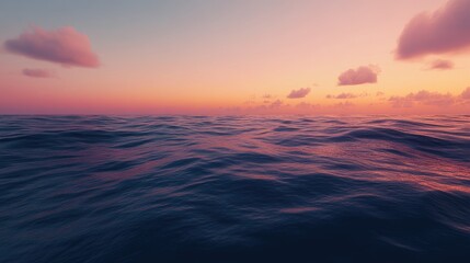 Obraz premium Tranquil waves of the Pacific Ocean reflecting vibrant sunset colors with soft clouds in the serene evening sky.