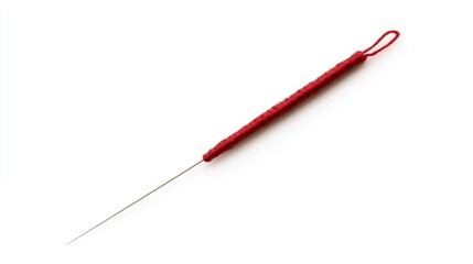 Fototapeta premium Red-handled sewing needle on a white background ideal for illustrating textile crafts and sewing concepts