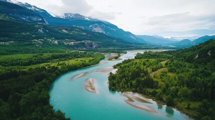 Obraz premium Serene Aerial View of Lush Green Valleys with Flowing River and Majestic Mountains in the Background
