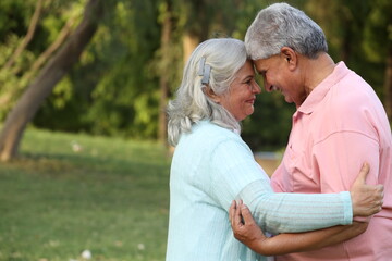 Obraz premium Indian happy senior beautiful couple embracing tohether and looking romantic and close together in garden