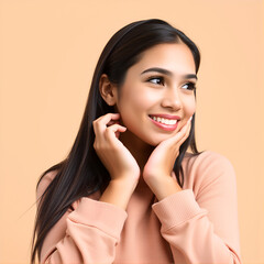 Young hispanic woman isolated on beige background keeps hands under chin, is looking happily aside.