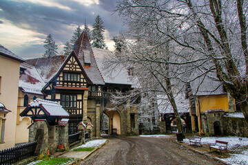 Naklejka premium Snow blanketing the entrance of peles castle, a neo-renaissance gem in the carpathian mountains near sinaia, romania, creates a picturesque winter landscape