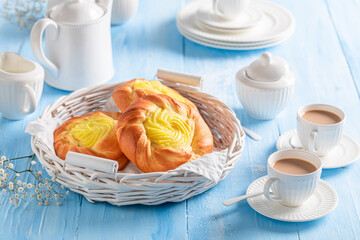 Fresh cheese yeast bun served with coffee in porcelain..
