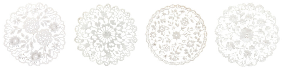 Elegant white lace doily patterns forming intricate floral and decorative designs on a plain white background Delicate