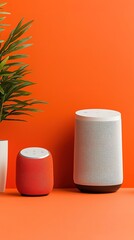 Voice Commerce Two stylish speakers in front of a vibrant orange background, accompanied by a green plant in a white pot, creating a modern and inviting atmosphere.