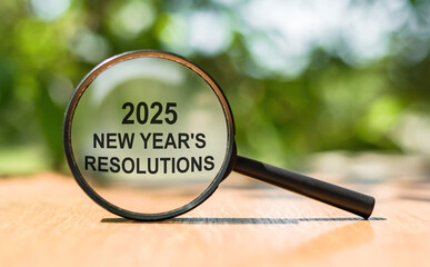 A magnifying glass focuses on the text highlighting 2025 New Year's resolutions, set against a...