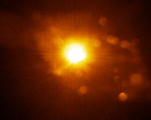 Obraz premium blurred image. shiny sun, sunbeams, sunrays, sunshine design. Yellow orange warm light effect, sun rays, golden beams isolated on black background. star dust
