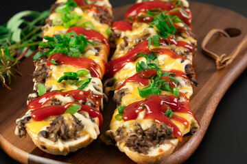 Toasted open-face sandwich made of a sliced baguette  topped with white mushrooms, cheese and...