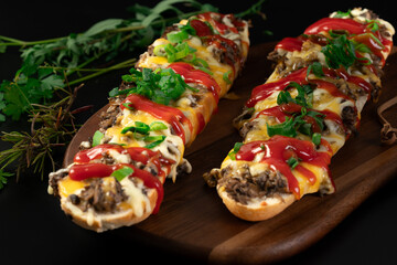Toasted open-face sandwich made of a sliced baguette  topped with white mushrooms, cheese and ketchup, zapiekanki