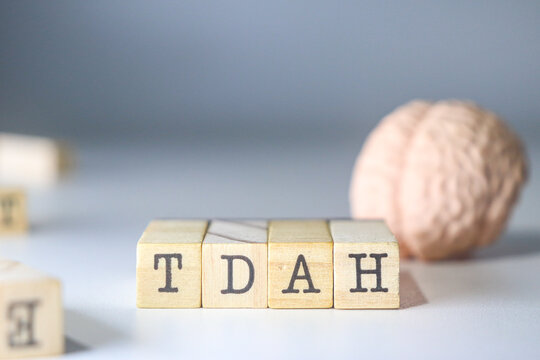 TDAH acronym mental health disease written on isolated wooden cubes with a brain on white background with copy space.