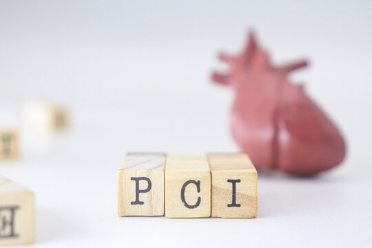 PCI word on wooden cubes isolated with heart on white background. Percutaneous Coronary Intervention concept of cardiology problems