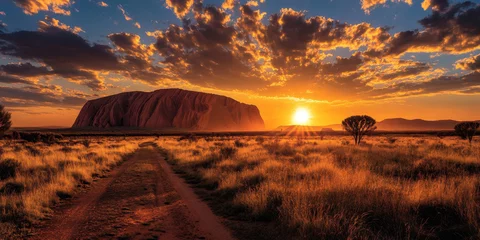 Selbstklebende Fototapeten Sun setting behind uluru at dusk in australian outback © bborriss