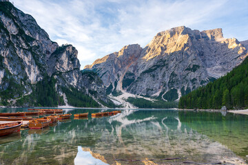 Boats resting on Braies Lake, also called Pragser Wildsee, amidst the dramatic Dolomites mountains in South Tyrol, Italy