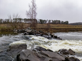 A river with rocks and water flowing over rocks in the middle of it