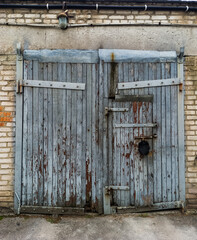A pair of old wooden doors on a brick building