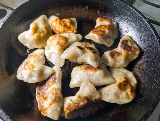 A pan filled with dumplings sitting on top of a stove top