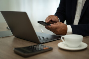 Fototapeta premium closeup of hand using smartphone and laptop , coffee in table Freelance work