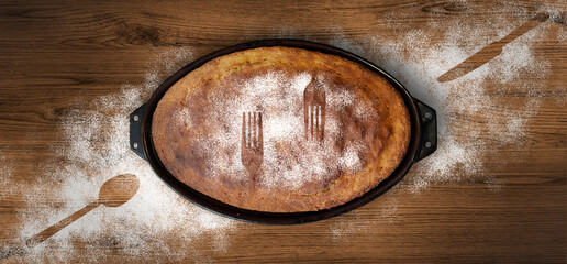 Home made baked bread in a vintage clay pot on wooden background covered in flour