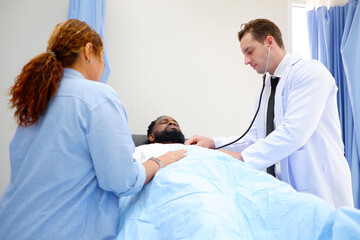 A doctor examines a patient lying on the bed.