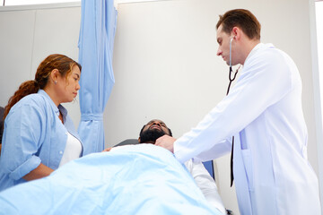 Fototapeta premium A doctor examines a patient lying on the bed.
