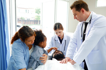 Female and male doctors are pushing a patient into the emergency room.