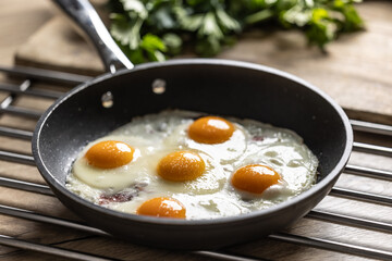 English breakfast on a pan. Ham and eggs sprinkled with parsley