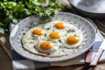 English breakfast on a plate. Ham and eggs sprinkled with parsley