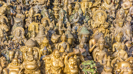 Fototapeta premium Little golden Buddha statues at a souvenir shop in Kathmandu, Nepal