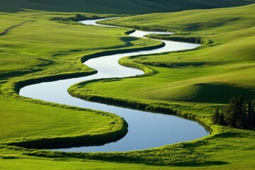 Obraz premium Meandering river lush green landscape with rolling hills