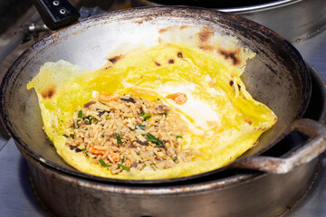Cooking Vietnamese savory crispy crepe in pans with gas stoves at street food in Thailand close up selective focus.	