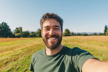 Happy man taking selfie in sunny green field on a bright day