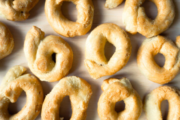 Flat lay of artisanal homemade typical apulian taralli, used as a baked snack in south italian culture. The taralli are placed on a clean and clear background