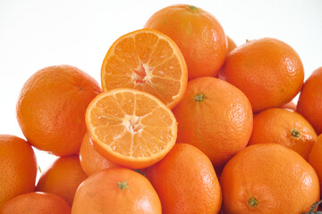 A halved mandarin orange on top of other fresh mandarins