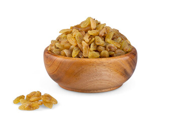 A wooden bowl of raisins beside some raisins on the table
