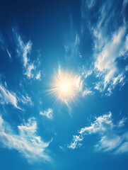 Bright sun shining through scattered clouds in a blue sky.