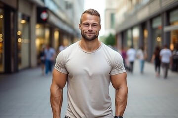 Fototapeta premium A man with a muscular build stands in a city street, smiling for the camera
