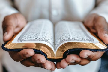 Naklejka premium World Religion Day. Close-up of hands holding an open sacred text, reflecting spirituality, faith, and devotion in a serene atmosphere.