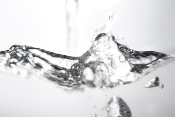 Water Splash Creating Ripples in Clear Liquid on White Background