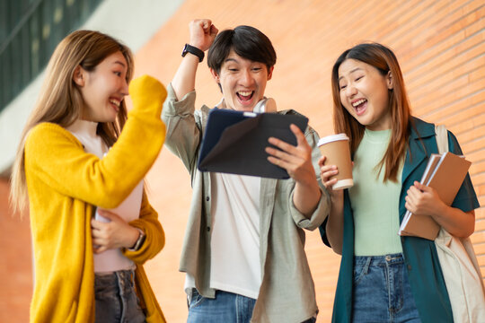 asian group friends student joyfully celebrating with tablet ready for school record at college campus.academic success concept.Students at university with fun for learning,Walking,laughing,bonding.