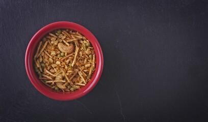 Directly above shot of Indian kashmiri mix snack food in red bowl on a plate of slate. 