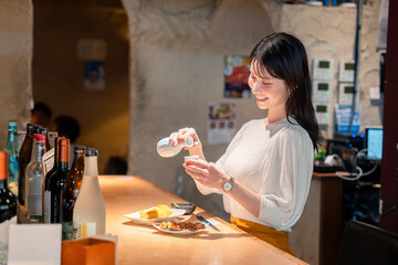 お店で一人でお酒を楽しむ女性