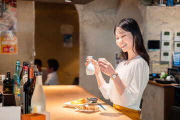 お店で一人でお酒を楽しむ女性