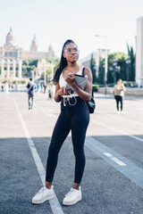 Thoughtful African American woman holding tablet and standing on street