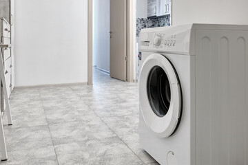 The washing machine stands in the hallway of a small budget apartment.