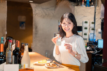お店で一人でお酒を楽しむ女性