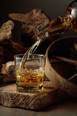 Whiskey is poured from a bottle into a glass.