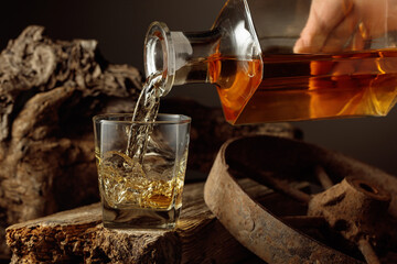 Whiskey is poured from a decanter into a glass.