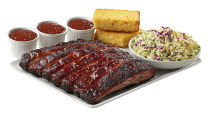 Delicious barbecue ribs served with cornbread, coleslaw, and dipping sauces in a casual dining setting.