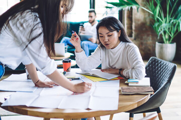 Concentrated businesswomen taking notes in office