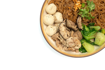 Dry rice vermicelli noodles mixed with dark soy sauce, fish balls, stewed pork, Chinese mustard greens on isolated white background. Top view, Close up